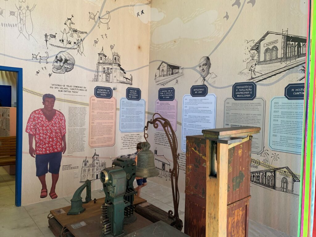 Parte da Estação de Memórias de Matozinhos, com ilustrações linha do tempo na parede e objetos restaurados.