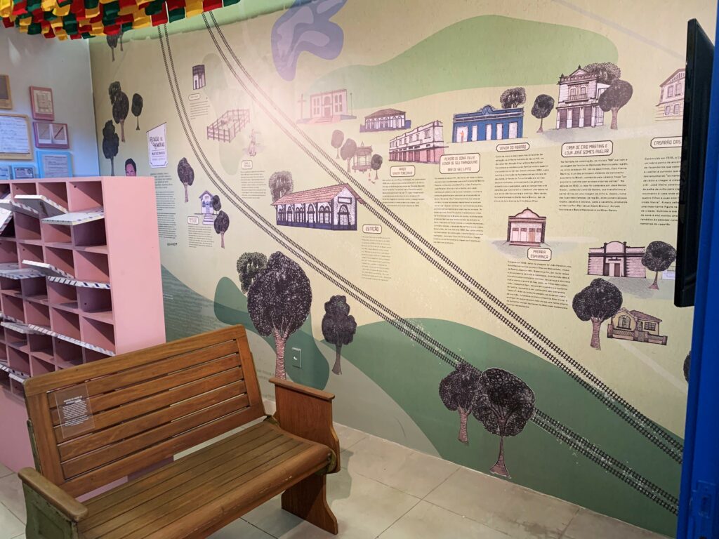 Parte da Estação de Memórias de Matozinhos, com ilustrações linha do tempo na parede e banco restaurado.