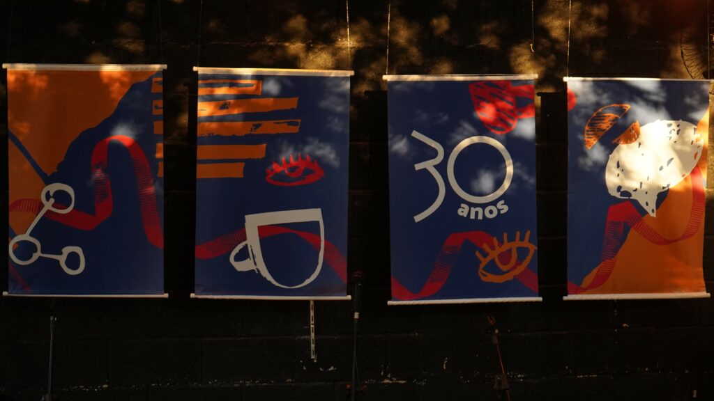 parede com 4 banners comemorativos dos 30 anos da aic